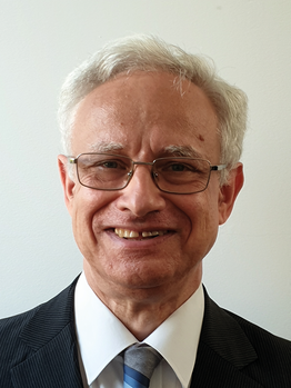 Idős férfi öltönyben Idős férfi öltönyt és nyakkendőt visel, szürke hajjal.