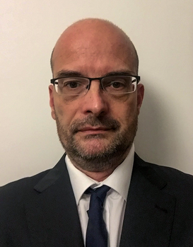 Formális öltözet sötét öltönyben és fehér ingben Formális öltözet, sötét öltöny, fehér ing és sötét nyakkendő látható a képen.