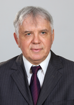 Férfi öltönyben és nyakkendőben, semleges háttérrel