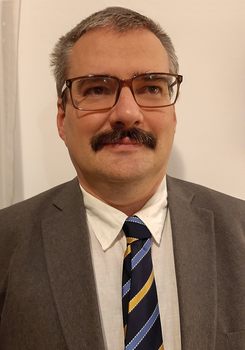 Férfi öltönyben és nyakkendőben, homályosított arccal