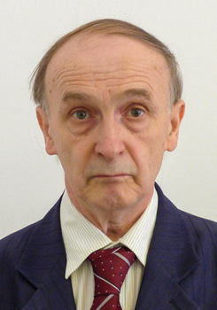 Formális öltözet, amely sötétkék zakót, világos csíkos inget és bordó nyakkendőt tartalmaz.