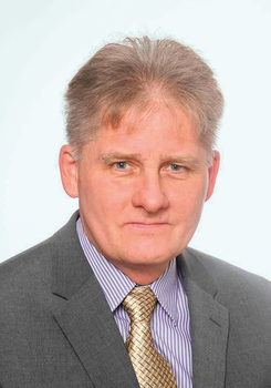 Férfi öltönyben, homályosított arccal, lila csíkos ing és arany nyakkendő.