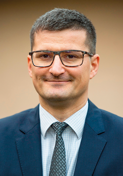 Férfi öltönyben és nyakkendőben, homályos háttérrel