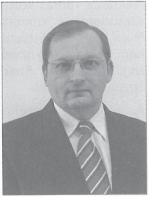 Öltönyös férfi homályosított arccal Egy öltönyös férfi látható, akinek az arca el van homályosítva.