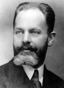 Fekete-fehér portré egy férfiról öltönyben Fekete-fehér portré, amelyen egy férfi öltönyben és nyakkendőben látható