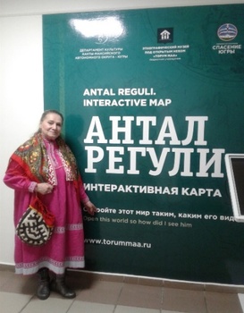 Hagyományos öltözetet viselő személy az Antal Reguli Interactive Map előtt