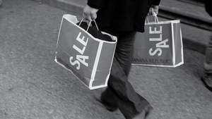 Ember két SALE feliratú bevásárlótáskát visz Egy ember két SALE feliratú bevásárlótáskát visz, Banana Republic márkájú táskák.