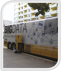 Big Data busz városi környezetben Busz a 'BIG DATA' felirattal és technológiai ikonokkal, városi háttérrel.