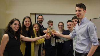 Csoport koccint pezsgőspoharakkal beltéri helyszínen Csoport pezsgőspoharakkal koccint egy beltéri helyszínen, ünneplés közben.