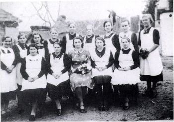 Csoportkép egyenruhás nőkkel Csoportkép, amelyen egyenruhás nők láthatók, valószínűleg egy közösségi eseményen.