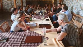 Csoportos megbeszélés egy étteremben Csoport ül egy hosszú asztal körül egy étteremben, italok és jegyzetek az asztalon.