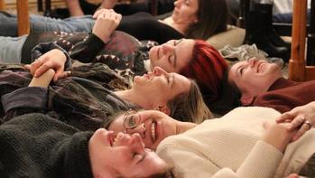 Csoportos relaxációs gyakorlat emberekkel Több ember fekszik a földön, valószínűleg csoportos relaxációs vagy meditációs gyakorlat részeként.