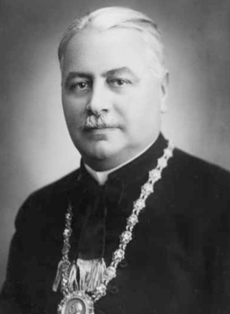 Egyházi személy díszes ruhában, lánccal és medállal Egyházi személy díszes ruhában, nyakában jelképes lánccal és medállal, fekete-fehér fotón.