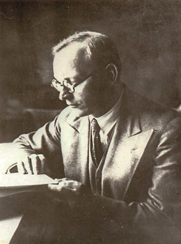 Elegáns öltönyben lévő férfi olvas egy könyvet, vintage stílusban.