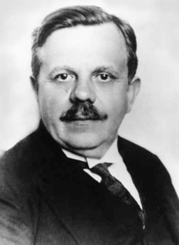 Elegáns férfi portré fekete-fehérben Fekete-fehér portré egy elegáns öltözetű férfiról, öltönyben és nyakkendőben.