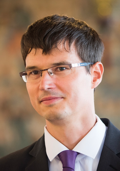 Elegáns öltönyben lévő személy fehér inggel és lila nyakkendővel