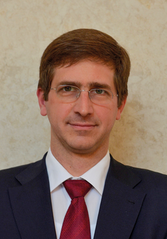 Elegáns öltöny piros nyakkendővel, világos háttér előtt