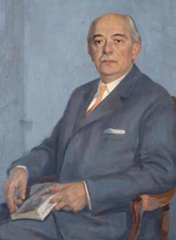 Elegáns öltönyös férfi könyvvel Elegáns öltönyben ülő férfi, aki egy könyvet tart a kezében, kék háttér előtt.