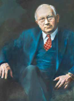 Elegáns férfi kék öltönyben piros nyakkendővel Elegánsan öltözött férfi kék öltönyben, piros mintás nyakkendővel, gyűrűvel a kezén.