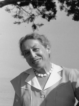 Elegáns nő gyöngysorral a faág alatt Elegáns nő gyöngysorral, faág és égbolt a háttérben, fekete-fehér fotó