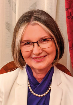 Elegáns női öltözet fehér blézerrel, lila felsővel és gyöngysorral