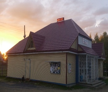 Épület digitális kijelzővel, idő és hőmérséklet Épület naplementében, tetején digitális kijelző mutatja az időt és hőmérsékletet, 12:40 21°C