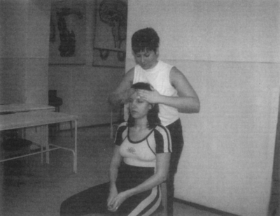 Fejmasszázs egy beltéri helyiségben Egy személy masszírozza egy másik személy fejét egy beltéri helyiségben.