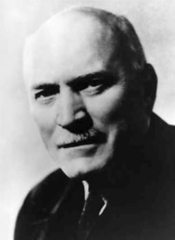 Fekete-fehér portré elmosódott háttérrel Fekete-fehér portré, amelyen egy személy vállai és feje körvonala látszik, elmosódott háttérrel.