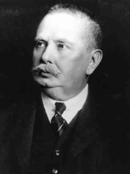 Férfi öltönyben nyakkendővel, fekete háttér előtt Férfi öltönyben és nyakkendővel, fekete háttér előtt, portré