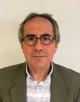 Férfi szürke zakóban és kockás ingben Férfi szürke zakóban és kockás ingben, háttérben semleges fal