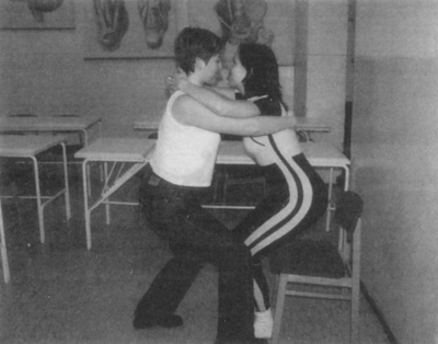 Két ember fizikai gyakorlatot végez egy szobában Két ember fizikai gyakorlatot végez egy szobában, ahol anatómiai modellek vannak a falon.