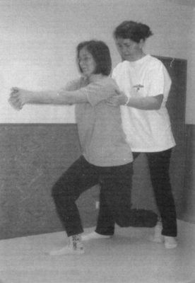 Fizikai terápia gyakorlat segítséggel Két ember fizikai terápia gyakorlatot végez, egyikük térdel, míg a másik segít neki.