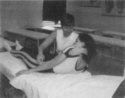 Fizikoterápiás kezelés, ahol egy terapeuta segít egy páciensnek a mozgásban.