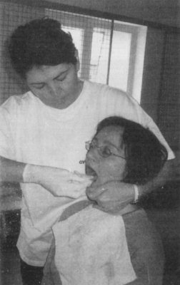 Fogorvosi vizsgálat egy pácienssel Fogorvos vizsgálja a páciens száját egy fogorvosi rendelőben.