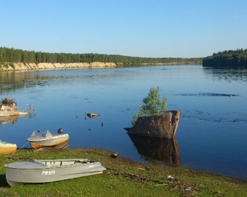 Folyópart csónakokkal és hajóronccsal Folyópart, ahol több csónak és egy félig elsüllyedt hajóroncs látható.