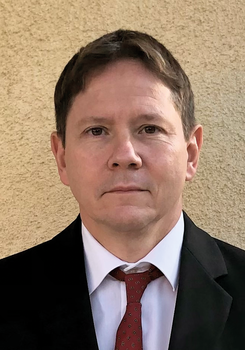 Formális öltözet, fekete zakó, fehér ing és piros nyakkendő látható a képen.