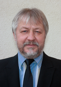 Formális öltözet, amely egy fekete zakóból, kék csíkos ingből és fekete nyakkendőből áll.