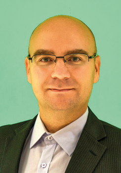 Formális öltözet, amely egy sötét öltönyből és világos ingből áll.