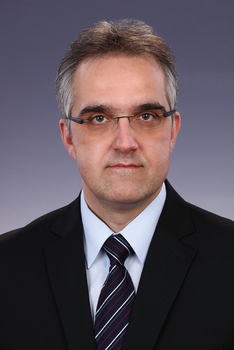 Formális öltözet sötét öltönyben, fehér inggel és csíkos nyakkendővel Formális öltözet, sötét öltöny, fehér ing és csíkos nyakkendő látható a képen.