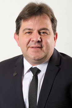 Formális öltözet sötét öltönyben és fehér ingben Sötét öltöny, fehér ing és pöttyös nyakkendő formális öltözetben