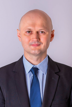 Formális öltözet sötét öltönyben, kék nyakkendővel Formális öltözet sötét öltönyben, kék nyakkendővel és kockás inggel