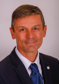 Formális öltözet, amely sötétkék zakóból, fehér ingből és kék nyakkendőből áll.