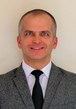 Formális öltözet, amely szürke zakóból, fehér ingből és fekete nyakkendőből áll