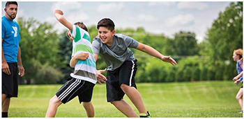 Gyerekek szabadban sportjátékot játszanak Gyerekek szabadban játszanak, valószínűleg egy sportjátékot játszanak a zöld füvön.