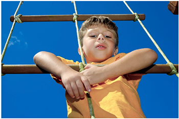 Gyermek mászókán játszik kék égbolt alatt Gyermek mászókán játszik, kék égbolt háttérrel, szabadidős tevékenység.