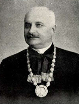 Idős férfi formális öltözetben díszes lánccal Idős férfi formális öltözetben, nyakában díszes lánc medállal