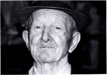 Idős férfi kalapban, fekete-fehér portré Idős férfi kalapban, fekete-fehér stílusú portré, öltönyben.