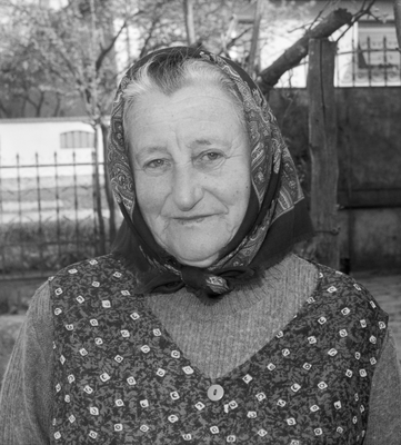 Idős nő hagyományos ruházatban, kendővel a fején, fekete-fehér kép