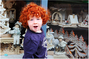 Karácsonyi dekorációk kirakatban Karácsonyi dekorációk kirakatban, fából készült házikók, fenyőfák és figurák láthatók.