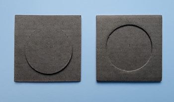 Két kartonlap látható, az egyik közepén kiemelkedő kör, a másik közepén bemélyedő kör.